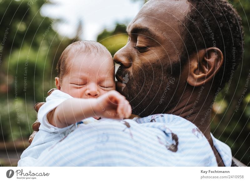 Black father holds newborn son in arms Life Child Human being Baby Man Adults Father Family & Relations 2 0 - 12 months 30 - 45 years Black-haired Touch