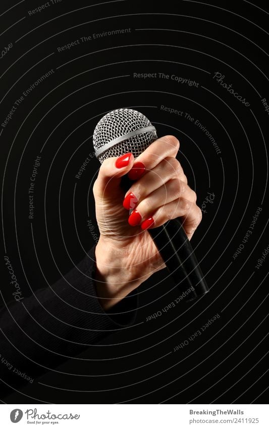 Woman hand holding microphone on black background Human being Adults Hand 1 Actor Shows Music Concert Stage Singer Musician Record Media Television Red Black