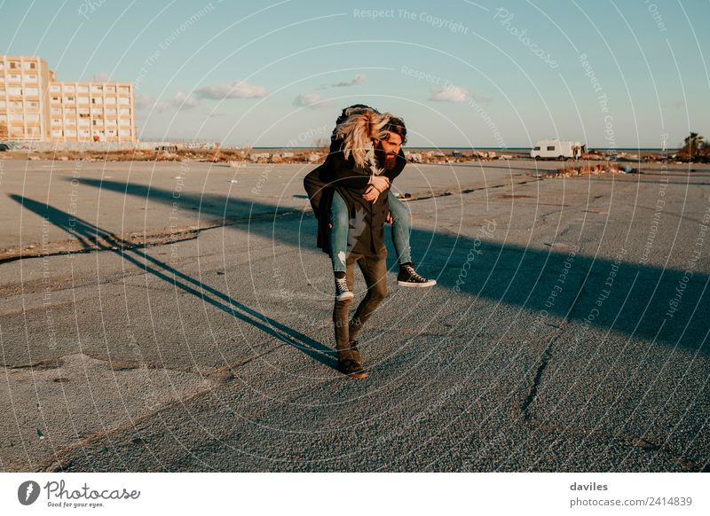 Man giving a piggy back to her girlfriend in a deserted city suburbs Lifestyle Joy Happy Playing Human being Young woman Youth (Young adults) Young man Woman