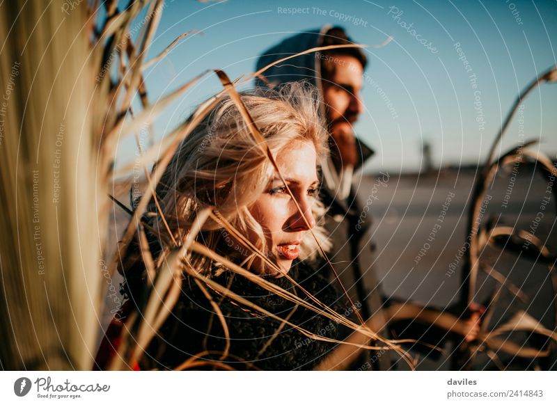 Blonde woman and bearded man looking at the sunset between plant branches. Lifestyle Joy Happy Beautiful Playing Summer Human being Young woman