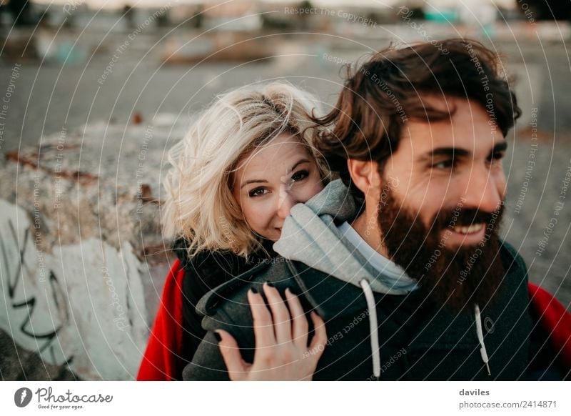 Blonde girl looks at camera while embraces her bearded boyfriend. Lifestyle Leisure and hobbies Human being Young woman Youth (Young adults) Young man Woman