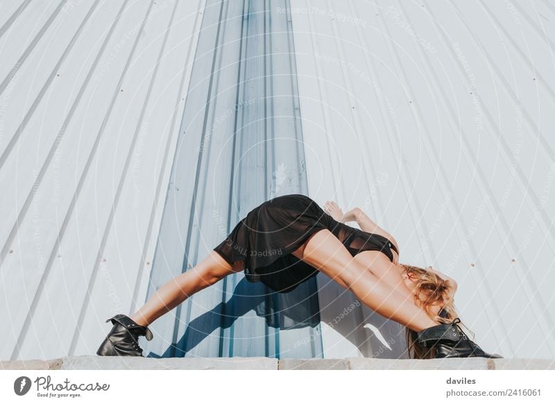 Blonde dancer in black dress against industrial wall. Lifestyle Elegant Beautiful Relaxation Dance Sports Human being Woman Adults 1 18 - 30 years