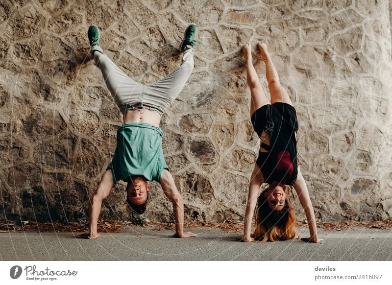 Young funny couple enjoying and doing a handstand Joy Happy Beautiful Human being Woman Adults Man Couple 2 18 - 30 years Youth (Young adults) Forest Street
