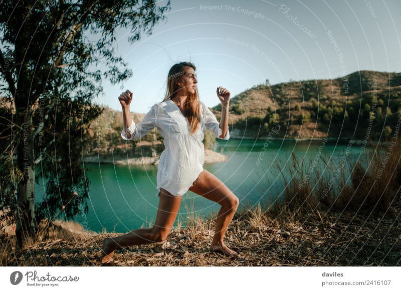 Woman posing in nature with a lake in the background Lifestyle Happy Beautiful Meditation Freedom Summer Sun Mountain Human being Adults 1 18 - 30 years