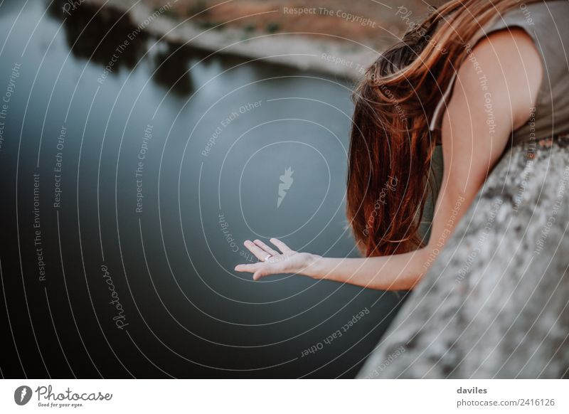 Woman looking out through a bridge, with a hand floating in the air. Lifestyle Ocean Human being Adults Hair and hairstyles Hand 1 18 - 30 years