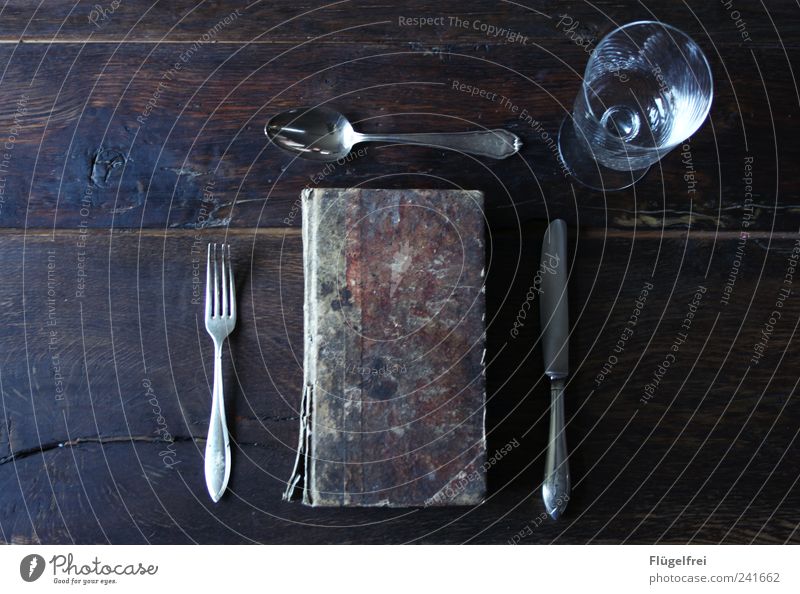 Book devouring - main course Cutlery Knives Fork Spoon Elegant Noble Ancient served Wine glass Arranged Dish Wooden table Structures and shapes Derelict