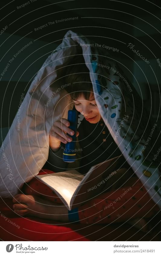Boy reading with a flashlight Joy Happy Beautiful Calm Leisure and hobbies Reading Bedroom Child Human being Boy (child) Man Adults Infancy Book Smiling Sleep