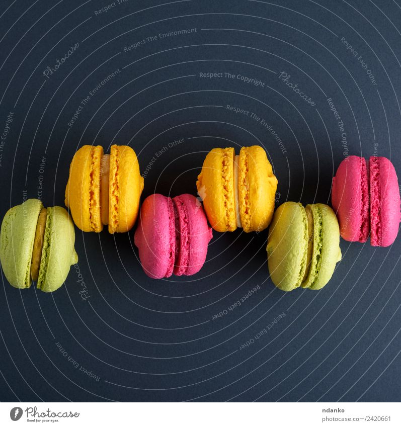 row of multicolored cakes Dessert Candy Eating Bright Yellow Green Pink Black Colour Macaron background food colorful Vanilla french Vantage point sweet biscuit