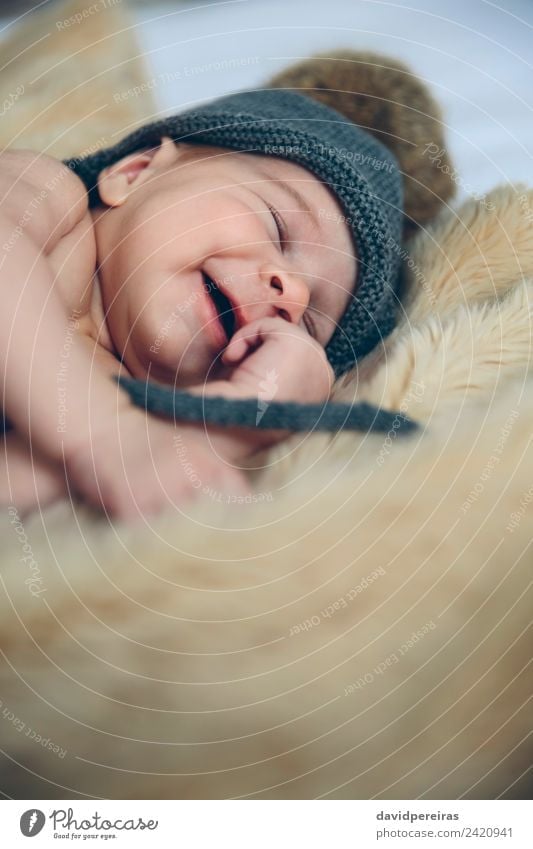 Newborn baby with pompom hat sleeping and laughing on blanket Happy Beautiful Calm Bedroom Child Human being Baby Woman Adults Warmth Hat Laughter Sleep Dream