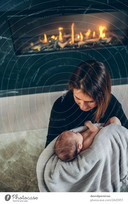Mother hugging her baby in front of fireplace Lifestyle Beautiful Fireside Living room Child Human being Baby Woman Adults Family & Relations Warmth Aircraft
