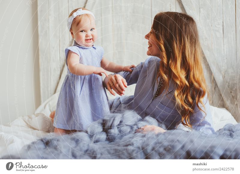 happy mother and 9 month old baby in matching pajamas Lifestyle Joy Playing Bedroom Baby Parents Adults Mother Family & Relations Infancy Hand Stripe Embrace