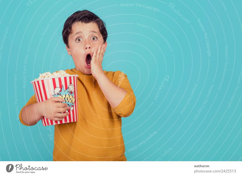surprised boy with popcorn on blue background Food Nutrition Eating Fast food Lifestyle Joy Leisure and hobbies Human being Masculine Child Toddler Boy (child)