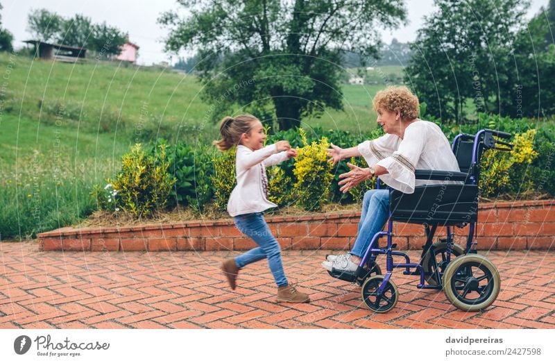 Granddaughter running to grandmother in wheelchair Lifestyle Happy Health care Relaxation Garden Human being Woman Adults Grandmother Family & Relations Nature