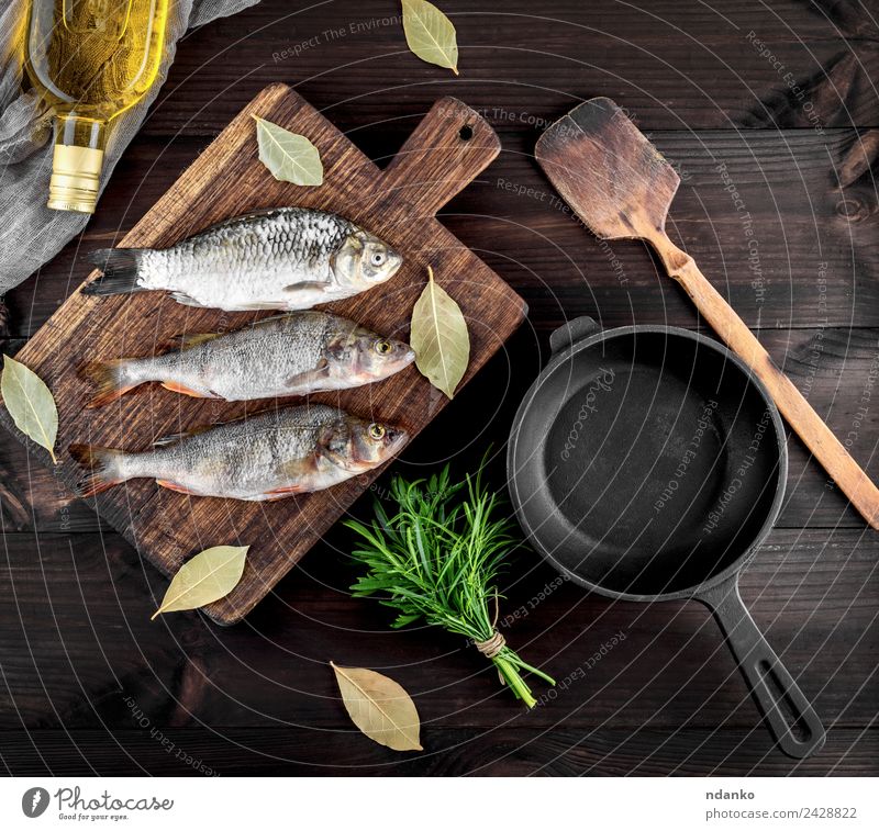 three river fish on a brown wooden board Fish Seafood Herbs and spices Nutrition Dinner Diet Pan Table Wood Eating Dark Fresh Above Retro Brown Black Perches
