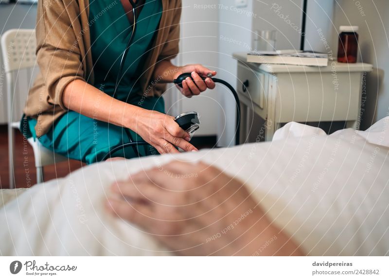 Caregiver checking blood pressure to a senior woman Health care Medication House (Residential Structure) Chair Examinations and Tests Doctor Hospital