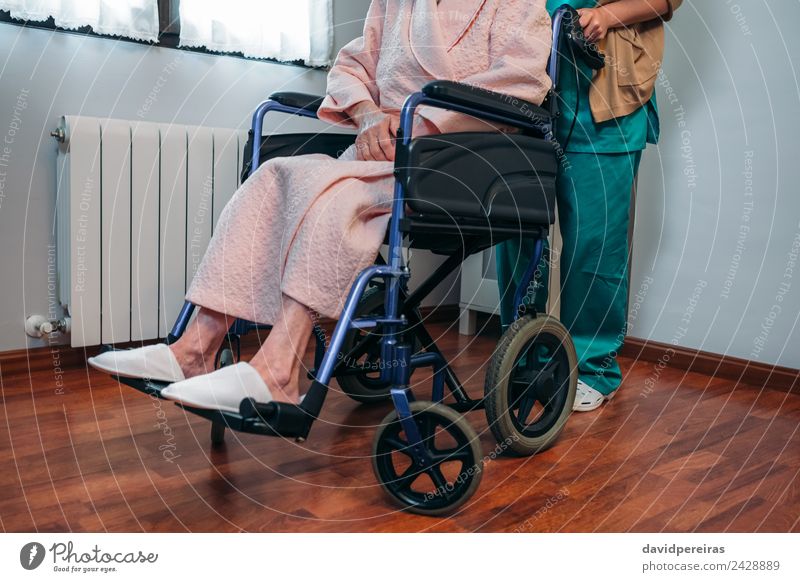 Doctor carrying elderly patient in a wheelchair Health care Illness Relaxation Hospital Human being Woman Adults Slippers Old Carrying Authentic Unrecognizable