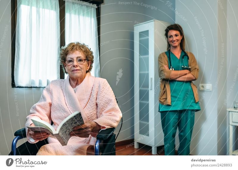 Senior patient posing with doctor in the background Health care Illness Relaxation Reading Bedroom Doctor Hospital Human being Woman Adults Book Old Smiling Sit