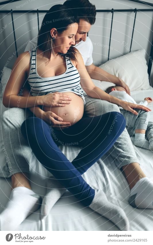 Pregnant woman with her husband looking son Beautiful Relaxation Bedroom Child Human being Baby Toddler Woman Adults Man Parents Mother Father