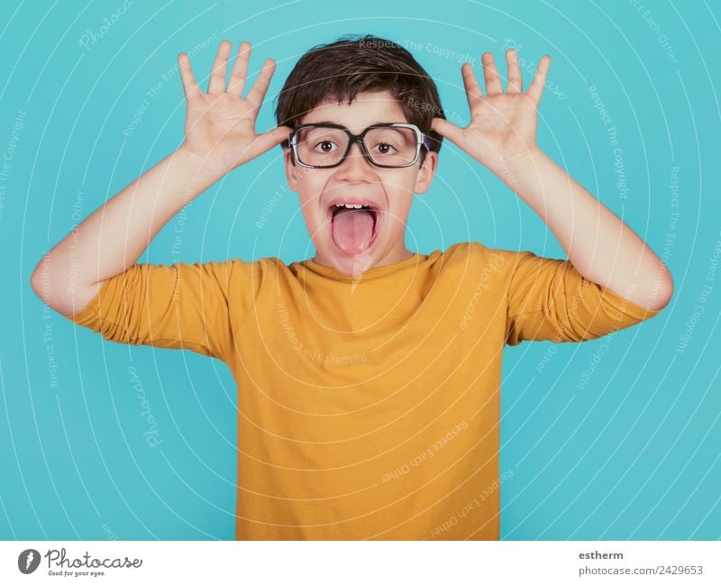 funny boy with glasses show out his tongue on blue background Lifestyle Joy Human being Masculine Child Toddler Boy (child) Infancy 1 8 - 13 years Eyeglasses