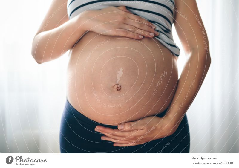 Serene pregnant woman in bra and panties holding stomach - Stock Image -  F030/0613 - Science Photo Library