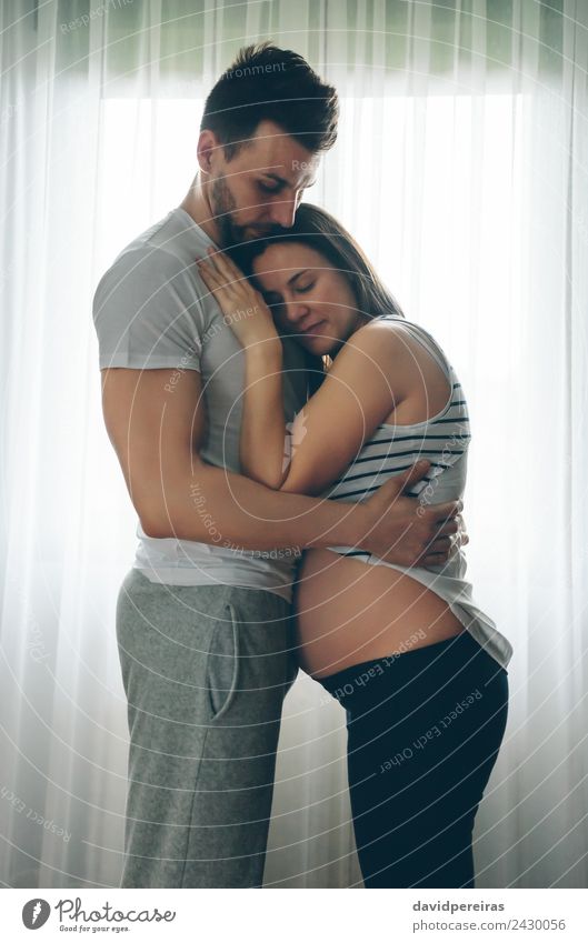 Pregnant woman embraced by her husband Lifestyle Beautiful Human being Baby Woman Adults Man Parents Mother Father Family & Relations Couple Partner Love