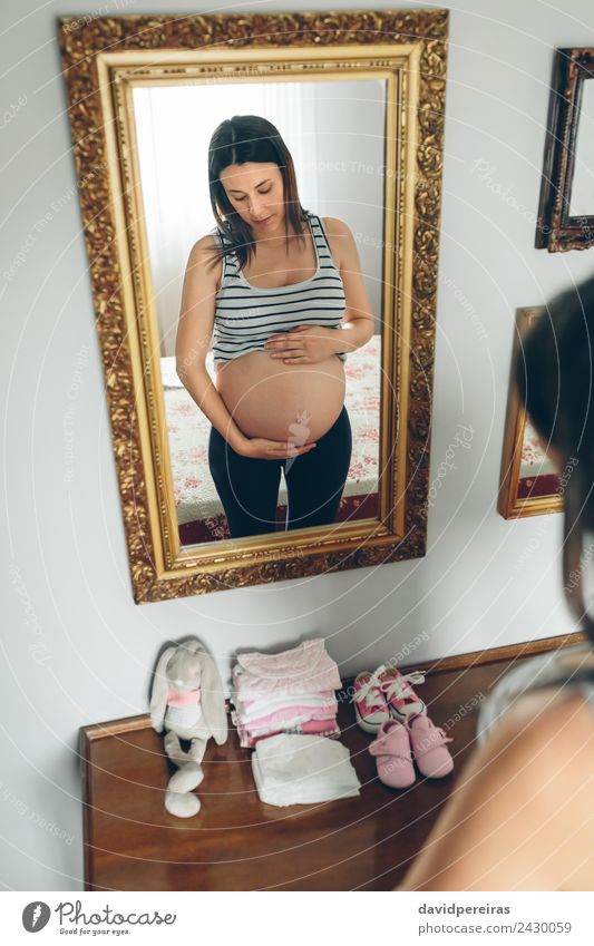 Pregnant woman looking her belly Lifestyle Beautiful Mirror Parenting Human being Baby Woman Adults Mother Hand Clothing Accessory Footwear Toys Teddy bear