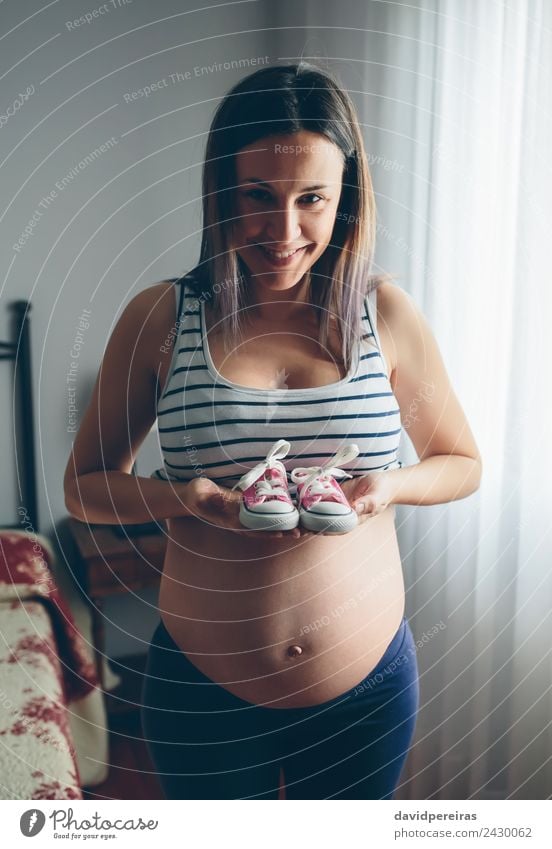 Pregnant showing baby sneakers Lifestyle Happy Beautiful Camera Human being Baby Woman Adults Mother Footwear Sneakers Smiling Wait Authentic Happiness Naked