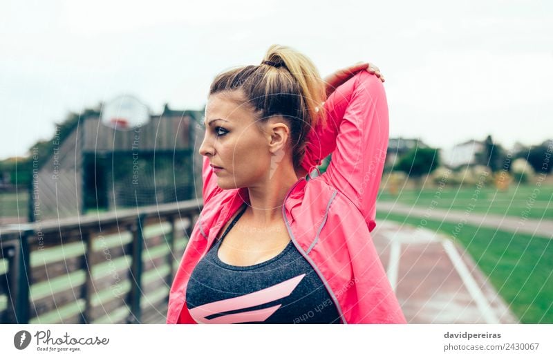 Young woman stretching arms before training outdoors Lifestyle Sports Jogging Racecourse Human being Woman Adults Arm Park Street Blonde Braids Line Fitness