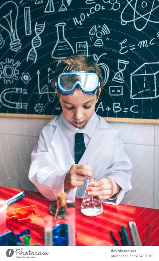Serious kid playing with chemical liquids Bottle Happy Playing Flat (apartment) Table Science & Research Child Classroom Blackboard Laboratory Human being