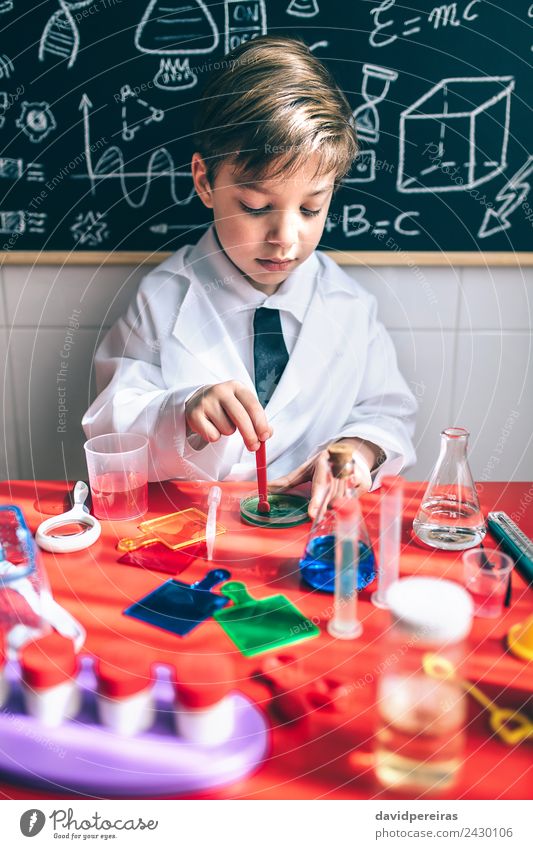 Kid playing to be chemist with colorful liquids Bottle Spoon Happy Playing Flat (apartment) Table Science & Research Child Classroom Blackboard Laboratory