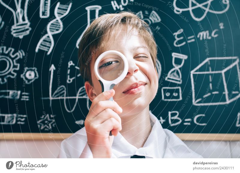 Little boy looking at camera through magnifying glass Joy Happy Playing Flat (apartment) Science & Research Child School Classroom Blackboard Laboratory