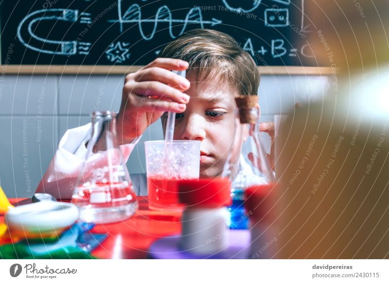 Kid playing with chemical liquids over table Bottle Happy Playing Flat (apartment) Table Science & Research Child Classroom Blackboard Laboratory Human being