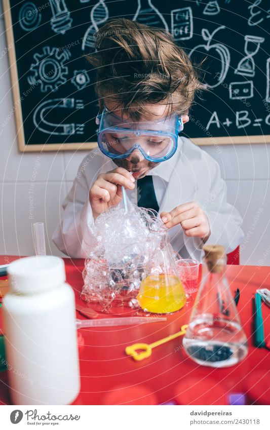 Kid doing soap bubbles with straw in glass Face Playing Flat (apartment) Table Science & Research Child School Classroom Blackboard Laboratory Human being