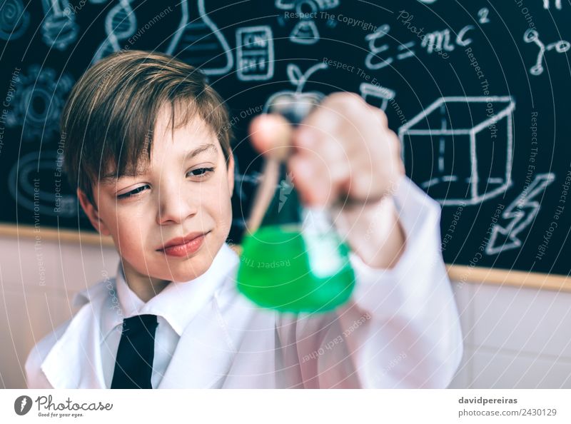 Scientist kid looking flask with chemical green liquid against of blackboard Playing Flat (apartment) Science & Research Child Classroom Blackboard Laboratory