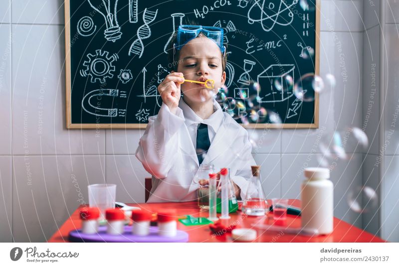 Boy playing with soap bubbles against of drawn blackboard Bottle Joy Happy Playing Flat (apartment) Table Science & Research Child School Classroom Blackboard