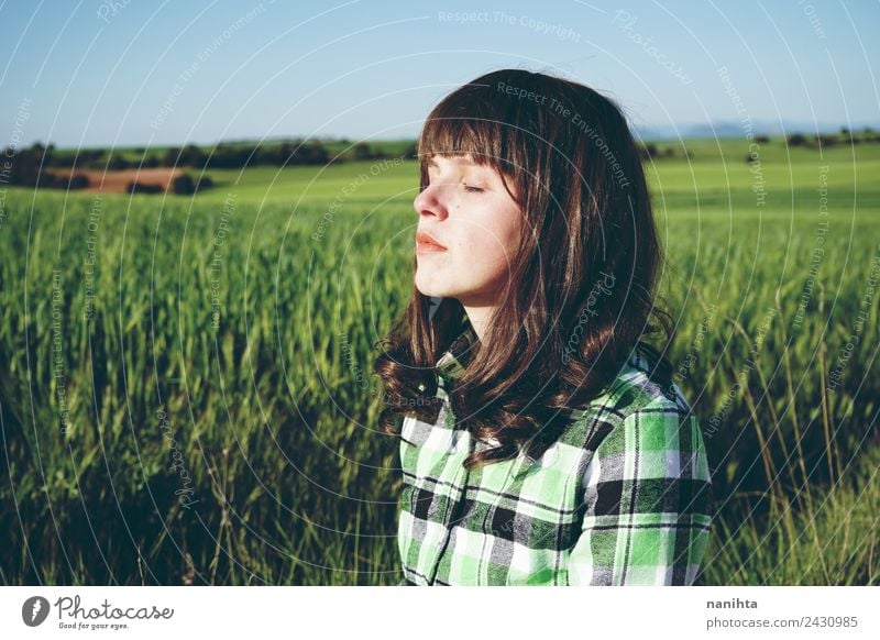 Young woman enjoying the sun in a green field Lifestyle Beautiful Healthy Harmonious Well-being Senses Relaxation Calm Meditation Agriculture Forestry