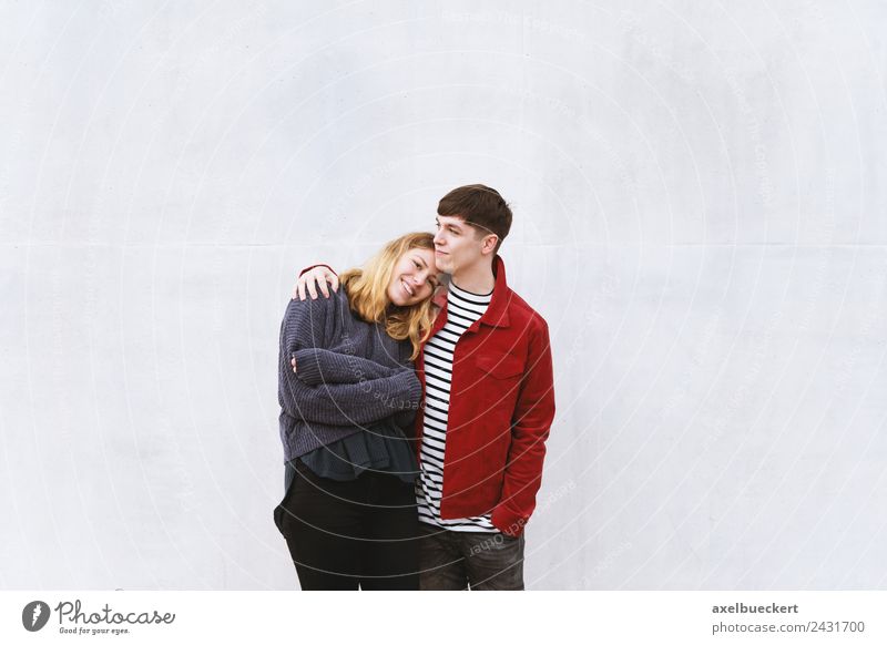 young couple in love in front of a concrete wall with free space for text Lifestyle luck Leisure and hobbies Human being Masculine Feminine Young woman