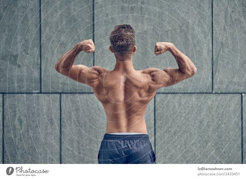 Fotografia do Stock: Sport and women. Rear view of strong fitness athlete,  female bodybuilder, flexing muscles, showing fit body, biceps and athletic  back, smiling satisfied, white background