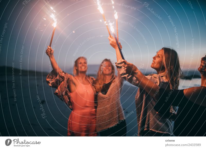 Group of friends celebrating New Years eve with sparklers Lifestyle Joy Happy Beautiful Summer Sun Beach Ocean Woman Adults Friendship Nature Sand Coast Blonde