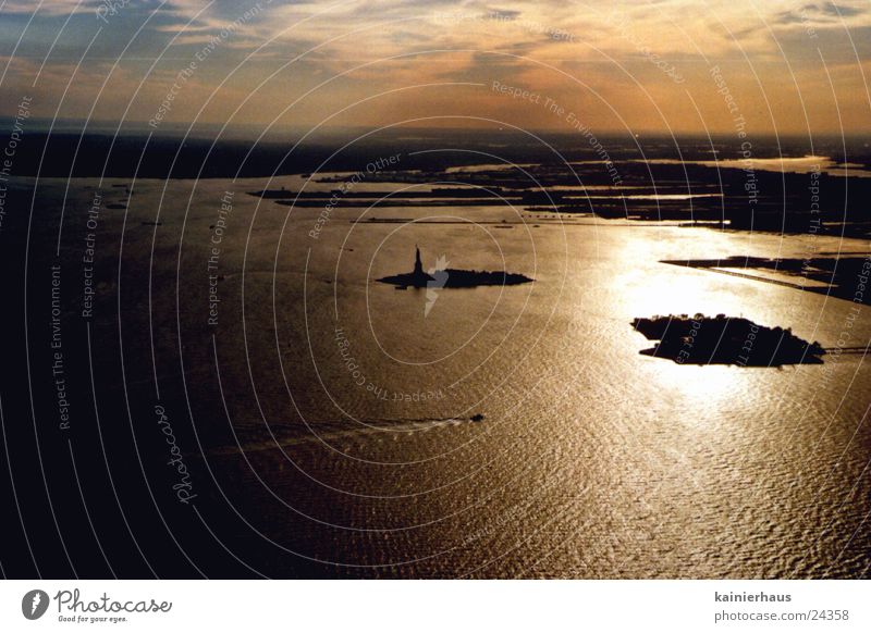 Statue of Liberty Sunset North America Water Sky Manhattan Atlantic Ocean Dusk Far-off places Horizon Aerial photograph Water reflection Silhouette