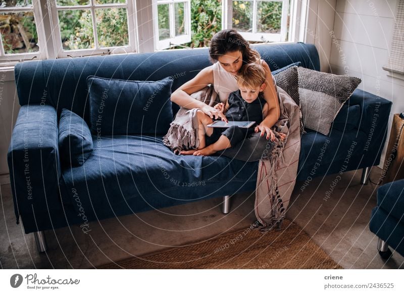 Caucasian mother and toddler son sitting on couch using tablet Lifestyle Joy Happy House (Residential Structure) Sofa Child Technology Toddler Woman Adults