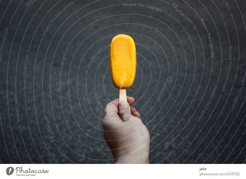 Ice on a stick Food Ice cream Candy Finger food Hand Delicious Sweet Yellow Gray Colour photo Exterior shot Deserted Copy Space left Copy Space right