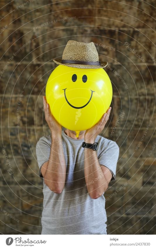 Eighth picture with yellow smiley Lifestyle Joy Leisure and hobbies Playing Man Adults Face 1 Human being 30 - 45 years 45 - 60 years Hat Straw hat Balloon Sign
