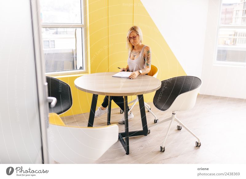 tattooed busy business woman writing notes in meeting room Beautiful Desk Chair Table Study Work and employment Profession Office Business Human being Woman