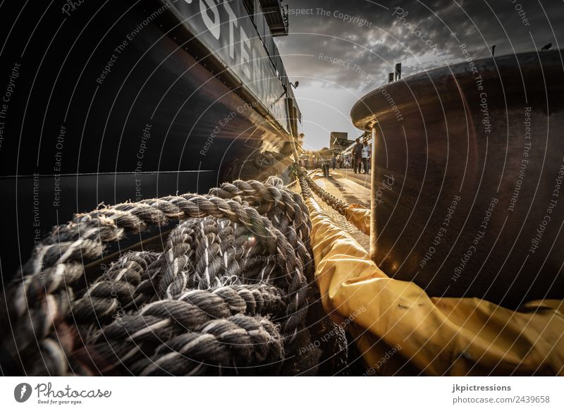 Ship with ropes, rope moored in Hamburg Germany Harbour Industry Clouds Sky Sun Steel Bollard Rope Old Rust Wide angle Dramatic Watercraft