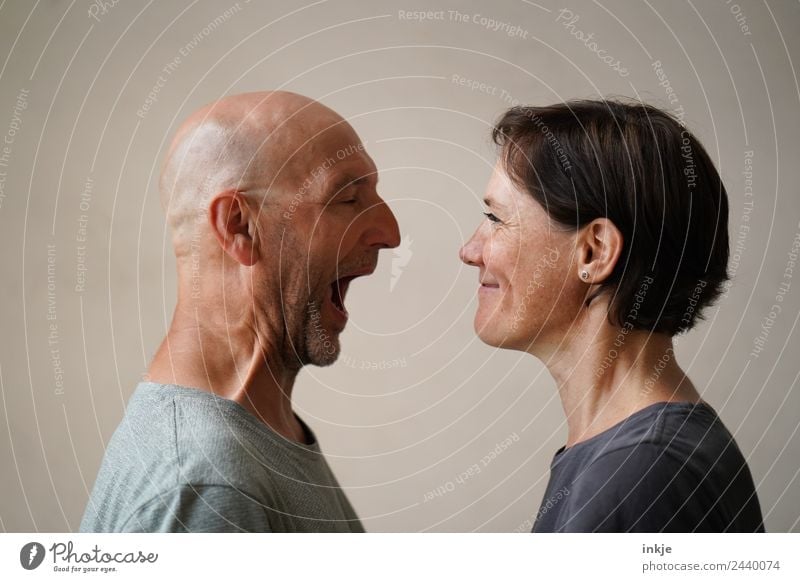 Man and woman face each other. The man opens his mouth wide, the woman grins. Lifestyle Leisure and hobbies Woman Adults Friendship Couple Partner Face 2