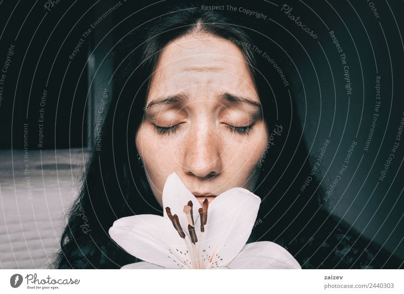 A Girl With A White Lily And Eyes Closed Worried A Royalty Free