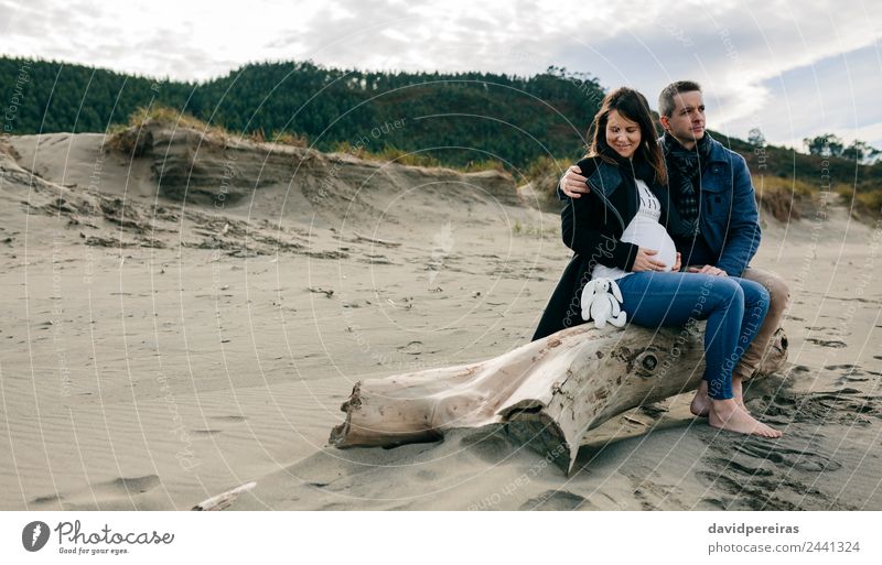 Pregnant on the beach with her partner Lifestyle Happy Beach Winter Human being Woman Adults Man Mother Father Couple Partner Feet Sand Autumn Coat Teddy bear