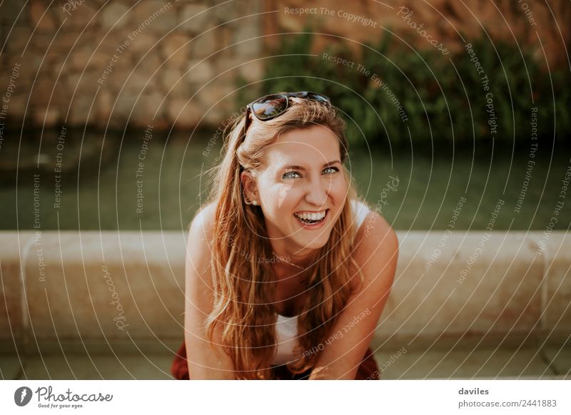 Young blonde woman portrait laughing outdoors sitting in a garden, and looking at camera. Joy Beautiful Face Human being Young woman Youth (Young adults) Woman