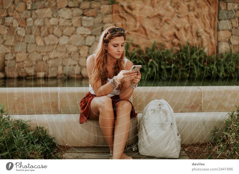 Blonde chic girl using a smart phone outdoors Lifestyle Beautiful Garden Telephone PDA Internet Human being Young woman Youth (Young adults) Woman Adults 1